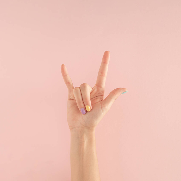 women hands with colorful nails on the pastel pink background. copy space.  summer modern tropical abstract art with female hand. minimal background idea. - Foto, imagen
