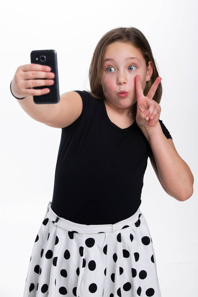 A young girl making a peace sign and pouting for camera. - Photo, Image