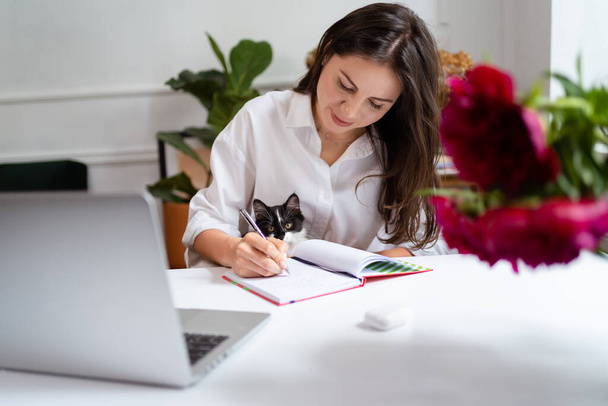 Imprenditrice che lavora sul computer portatile seduta a casa e gestisce la sua attività tramite home office - Foto, immagini