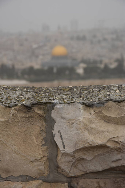 Jerusalem Israel 27 March 2021: view of the old city with the wall and the golden dome of the mosque on a foggy day. High quality photo - Photo, Image