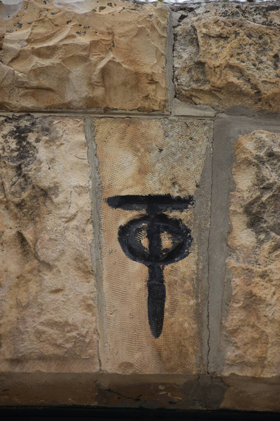 Kudüs İsrail 27 Mart 2021: Çemberli siyah haç, eski bir tuğla duvarda dini sembol. Yüksek kalite fotoğraf - Fotoğraf, Görsel