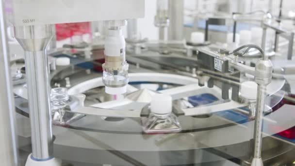 Línea de fabricación farmacéutica automatizada, botellas llenas de líquido - Metraje, vídeo