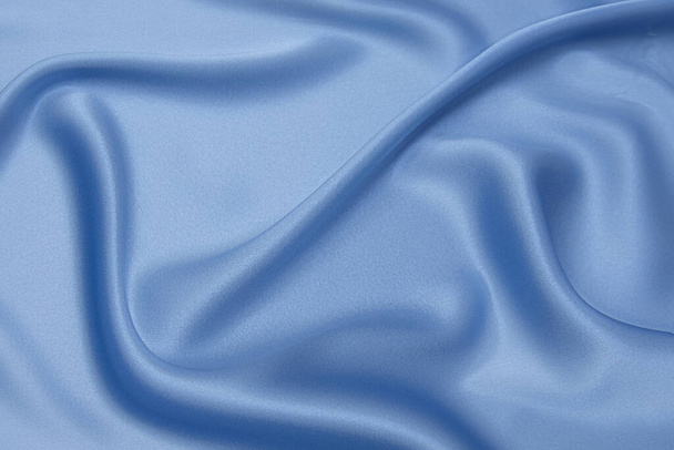 Синя тканина текстури фон, хвиляста тканина м'який синій колір, розкішна атласна або шовкова текстура тканини
. - Фото, зображення
