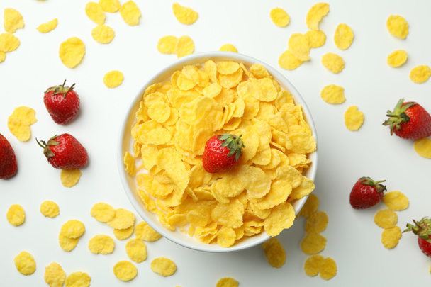 Concept de petit déjeuner savoureux avec des flocons de maïs et de fraise sur fond blanc - Photo, image