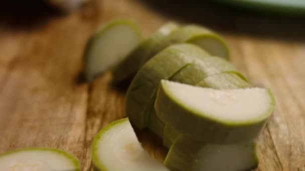 Der Koch schneidet die Zucchini in sehr angenehmer Atmosphäre. 4k-Kinematographie-Videorezept - Filmmaterial, Video