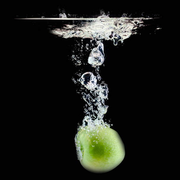 one ripe green apple fell into the water - 写真・画像