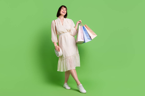 Full length body size photo woman in spring wearing glamour outfit bag keeping bags after sale isolated pastel green color background - Φωτογραφία, εικόνα