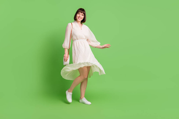 Full length body size side profile photo smiling woman throwing dotted dress skirt in spring isolated pastel green color background - Photo, Image