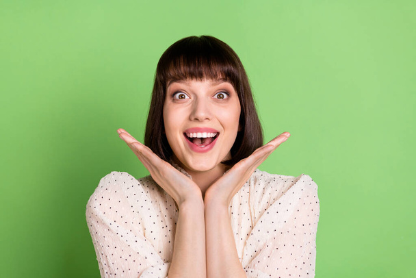 Photo of young cheerful girl happy positive smile amazed shocked news isolated over green color background - Foto, Imagem