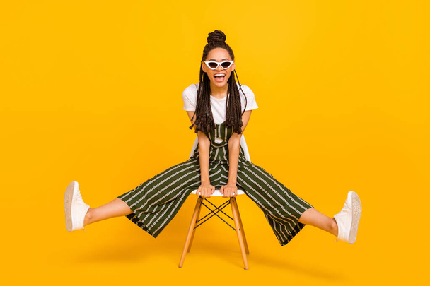 Full body photo of young african girl happy positive smile sit stool excited isolated over yellow color background - Foto, Imagem