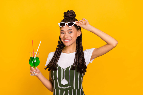 Photo of young happy dark skin woman hold cocktail alcohol smile vacation isolated on yellow color background - Photo, Image