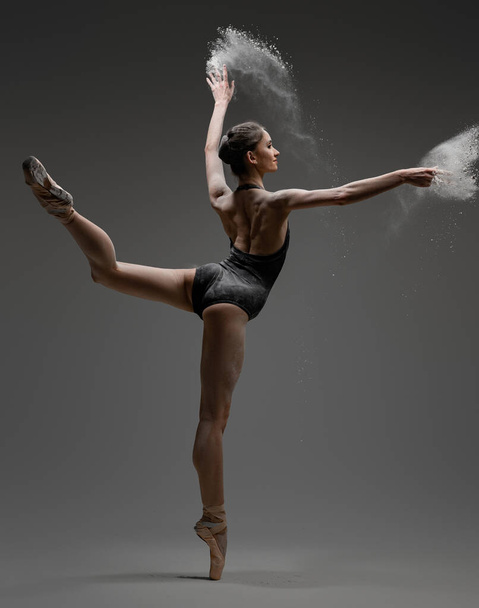 Artistic ballerina wearing black activewar and dancing - Фото, изображение