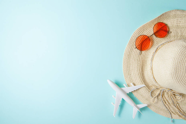 Summer 2021 vacation and travel background with sun hat, plane, sunglasses. Flat lay. - Photo, image