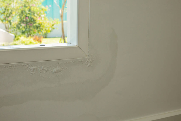いくつかの水汚れと窓の近くの家の壁は剥離塗料を示す - 写真・画像
