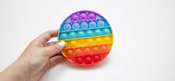 Rainbow antistress Pop it fidget toy on grey background with copy space. Vista superior - Foto, Imagem