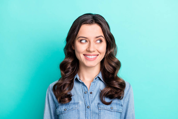 Photo of shiny adorable young lady dressed denim shirt arm smiling looking empty space isolated teal color background - Photo, image