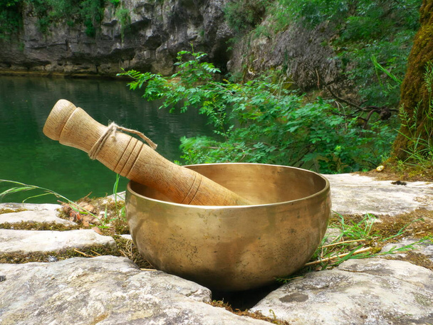 Співоча чаша, розміщена в природі з річкою на задньому плані
 - Фото, зображення