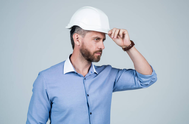 mature bearded businessman in helmet. confident guy pointing finger on copy space. - Photo, Image