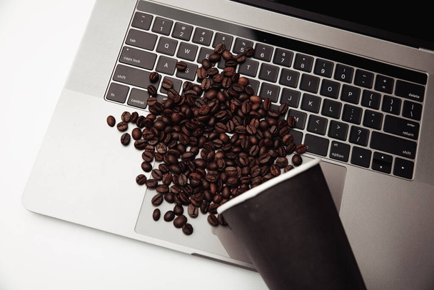 Une tasse de café et de grains de café sur le clavier au bureau blanc - Photo, image