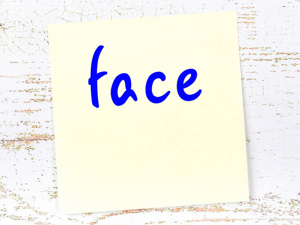 Έννοια της υπενθύμισης για το πρόσωπο. Κίτρινο κολλώδες φύλλο χαρτιού σε ξύλινο τοίχο με επιγραφή - Φωτογραφία, εικόνα
