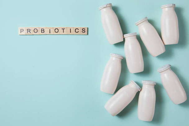 Bottles with probiotics and prebiotics dairy drink on light blue background. - Фото, изображение