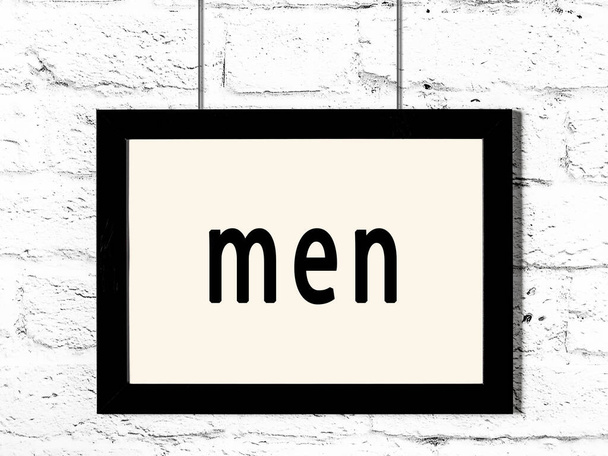 Cadre en bois noir avec inscription hommes suspendus au mur de briques blanches  - Photo, image