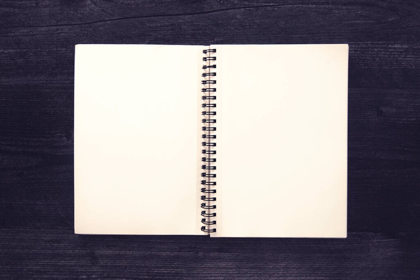 Blanco notitieboekje op een zwarte houten tafel - Foto, afbeelding