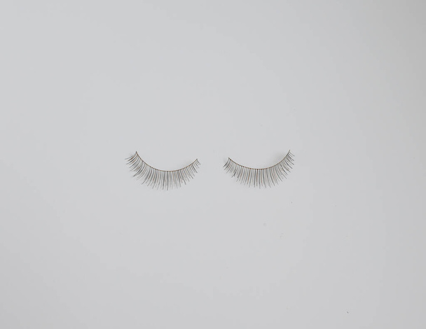 Two false eyelashes against plain white background with copy space - Photo, Image