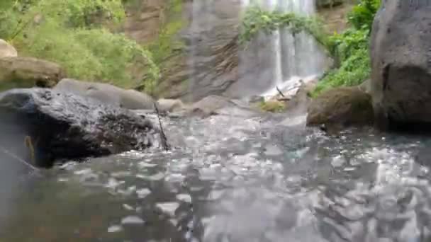 Alacsony látószögű kilátás a víz alján egy vízesés a dzsungelben. - Felvétel, videó