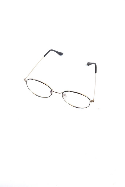 isolation glasses on white background. Black and gold round metal eyeglass frame in the photo from above on a white background - Photo, Image