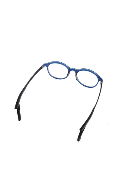occhiali di isolamento su sfondo bianco. Occhiali rotondi con serrature per orecchie blu doff. occhiali nella fotografia dall'alto su uno sfondo bianco - Foto, immagini