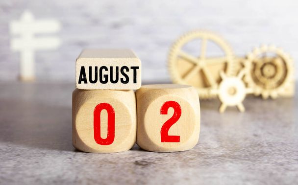 August 2. Date of August month. Number Cube with a flower and notebook on Diamond wood table for the background. - Photo, Image