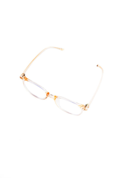 Průhledné broskvové obdélníkové brýle se zaoblenými tečkami na rámu, na bílém pozadí na fotografii z polevy - Fotografie, Obrázek
