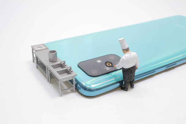 міні шеф-кухаря на мобільному телефоні об'єктив
 - Фото, зображення
