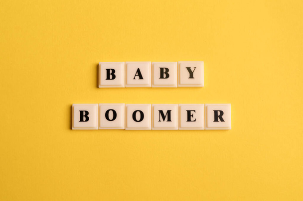 Квадратные буквы с текстом BABY BOOMER изолированы на желтом фоне - Фото, изображение