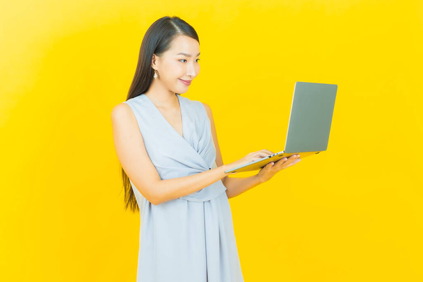 Portret mooie jonge aziatische vrouw glimlach met computer laptop op geïsoleerde achtergrond - Foto, afbeelding
