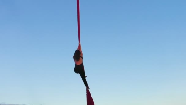 Žena demonstruje triky na výšinách, extrémní sport letecké gymnastiky. - Záběry, video