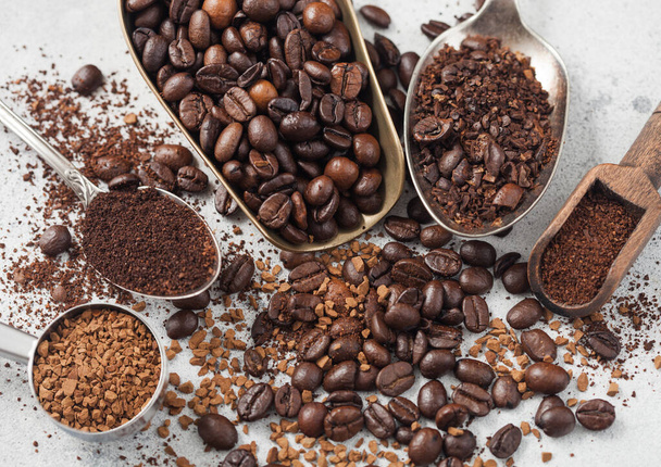 Fagyassza szárított instant kávé granulátum babbal és őrölt kávé különböző kanalakban és lapátok fehér alapon. Felülnézet - Fotó, kép