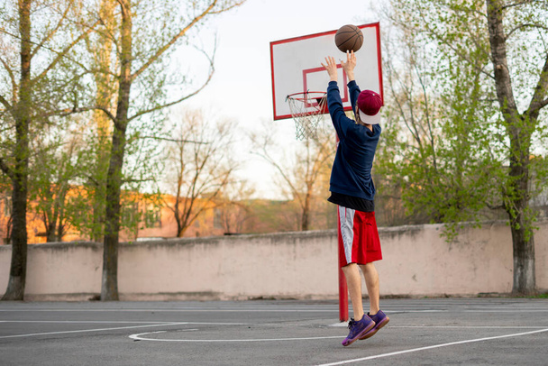 joueur de basket-ball faisant des exercices de tir en plein air dans les courts de rue de la ville - Photo, image