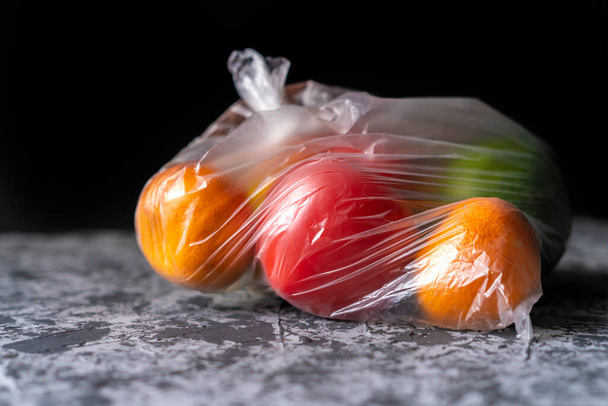 beschädigte verdorbene Früchte in einer Tüte in einem dunklen Raum, Plastikbehälter Schaden Konzept b - Foto, Bild