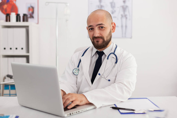 Portret lekarza specjalisty patrzącego w kamerę podczas spotkania medycznego - Zdjęcie, obraz