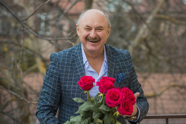 Older happy Senior man with a bouquet of flowers waiting on a date. Mature people lifestyle - Фото, зображення