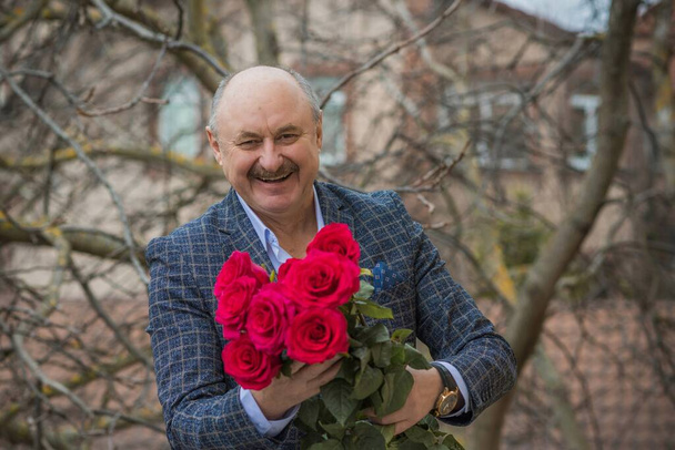 Older happy Senior man with a bouquet of flowers waiting on a date. Mature people lifestyle - Фото, зображення