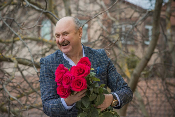 Older happy Senior man with a bouquet of flowers waiting on a date. Mature people lifestyle - Foto, Bild
