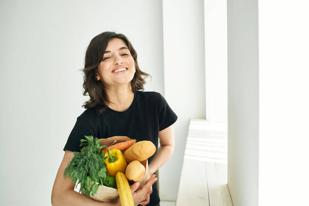iloinen nainen paketti päivittäistavaroiden kanssa kotitehtäviä terveellistä ruokaa - Valokuva, kuva