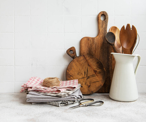 Przybory kuchenne, narzędzia i naczynia na tle białej ściany płytek. Wnętrze, nowoczesna kuchnia w jasnych kolorach. Puste miejsce na tekst, widok z przodu - Zdjęcie, obraz