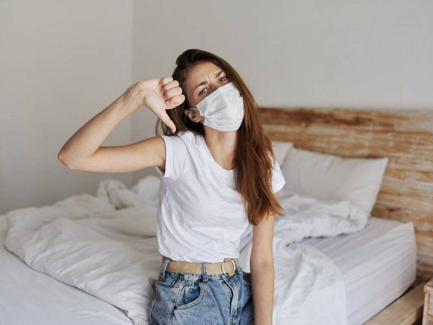woman in dormitory thumb down medical mask dissatisfaction - Valokuva, kuva