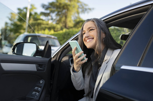 mujer en coche con smartphone enviando mensaje de voz - Foto, imagen