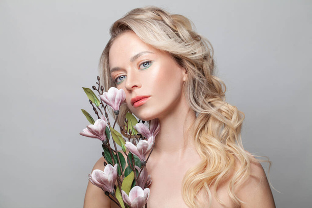 Beauty portrait of female face with natural skin and long blonde hair on white - Fotó, kép