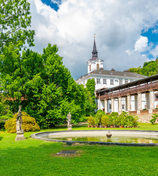 Lysice castle, Czech Republic. Famous baroque castle built in 14th century. Beautiful formal garden, palm trees and flowers. Promenade near the castle. Sunny day, dramatic clouds before storm. - Φωτογραφία, εικόνα
